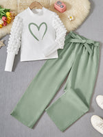 Girl's casual outfit with heart print, featuring a textured patchwork long-sleeve top with puff sleeves and straight pants with a belt in soft fabric.