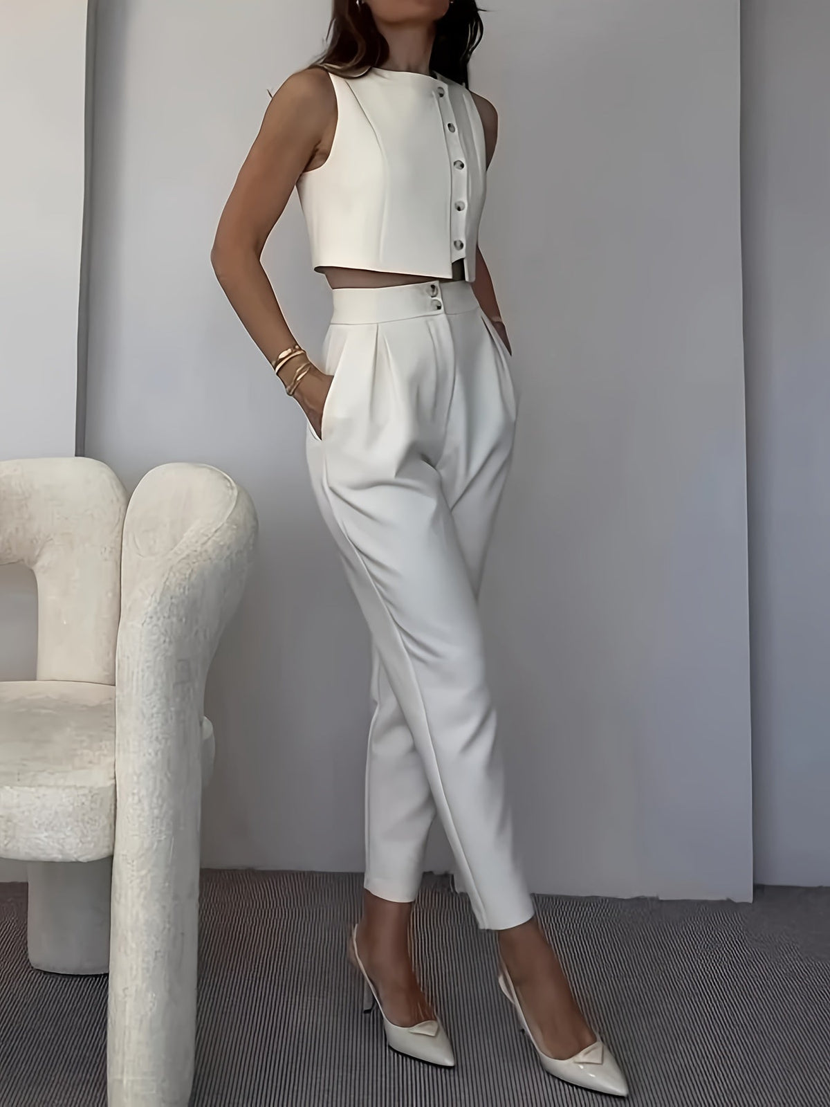 Elegant women's ensemble with sleeveless vest and pleated pants for chic style.