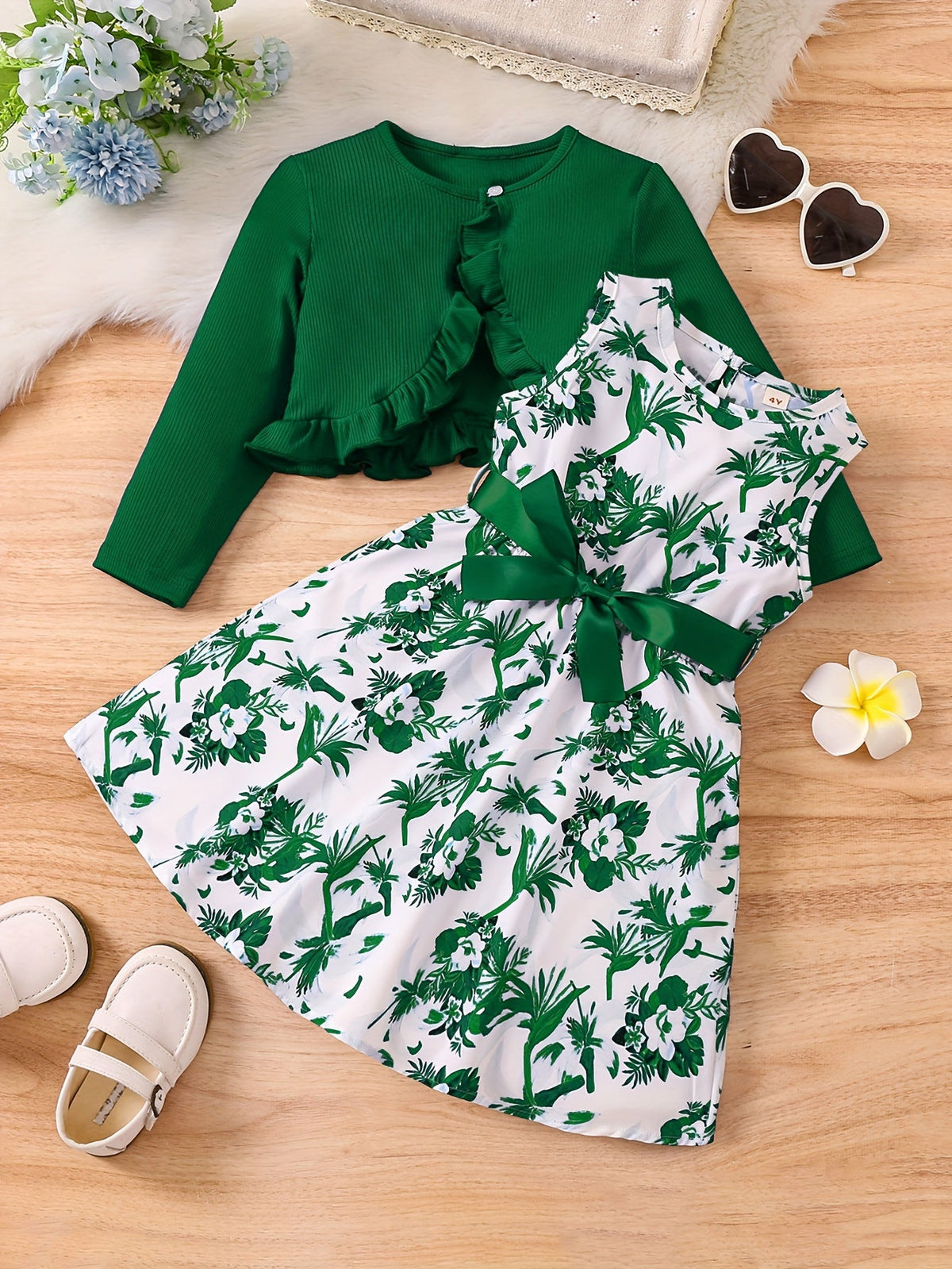 Blue floral romantic ensemble for girls with dress and cardigan on wooden background.