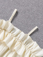 Robe d'été pour filles avec dentelle et design élégant à une épaule, dentelle blanche et bretelles sur fond gris.
