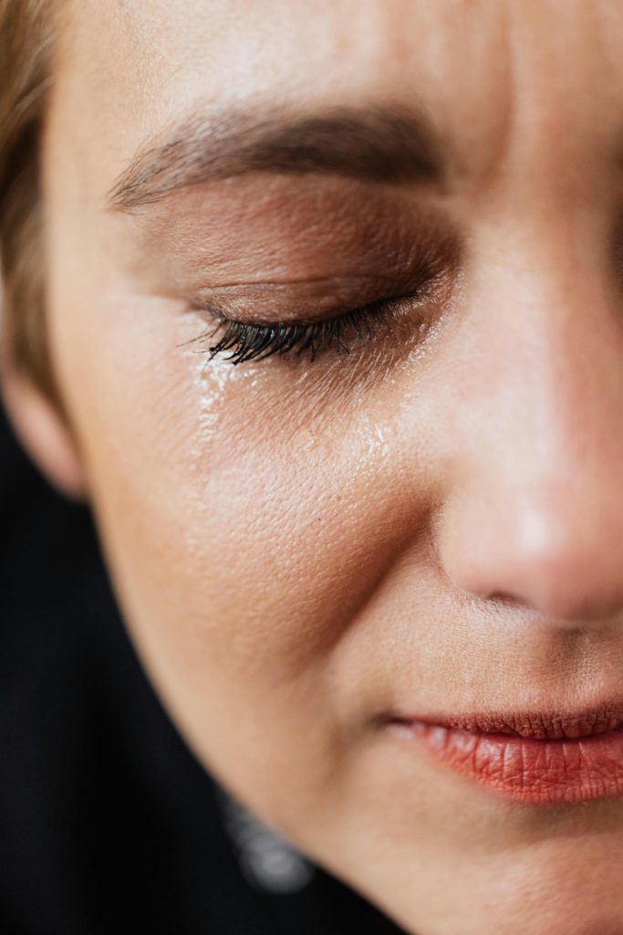 Close-up d'une femme adulte triste avec un maquillage naturel ayant des problèmes et pleurant seule