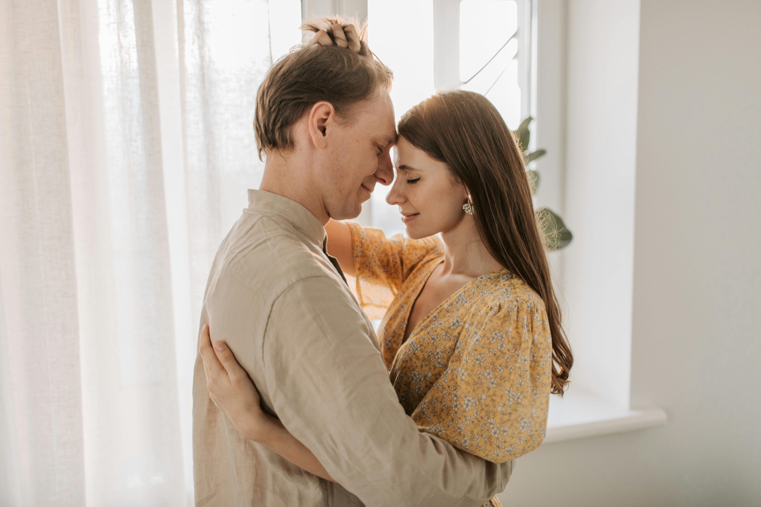 A loving couple embraces in a bright, sunlit room, exuding warmth and togetherness. Un couple aimant s'enlace dans une pièce lumineuse et ensoleillée, dégageant chaleur et complicité.