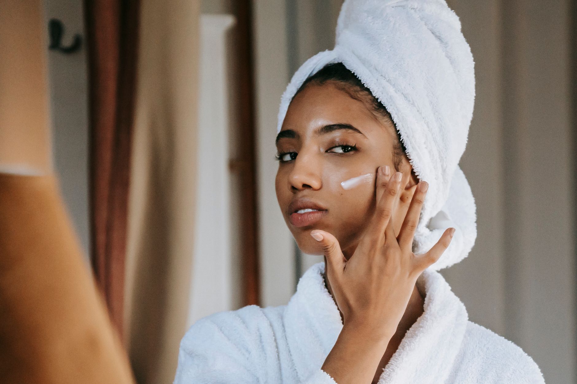 Femme qui observe sa peau dans un miroir