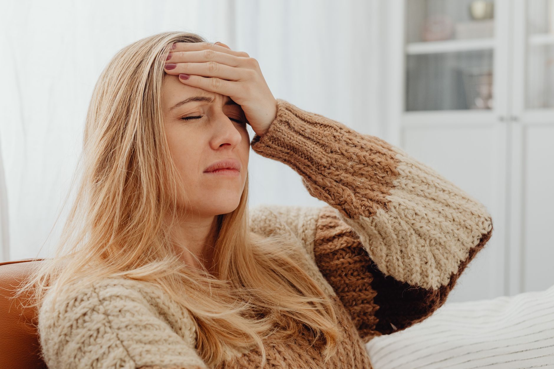 Femme se tenant le front à cause d un mal de tête intense