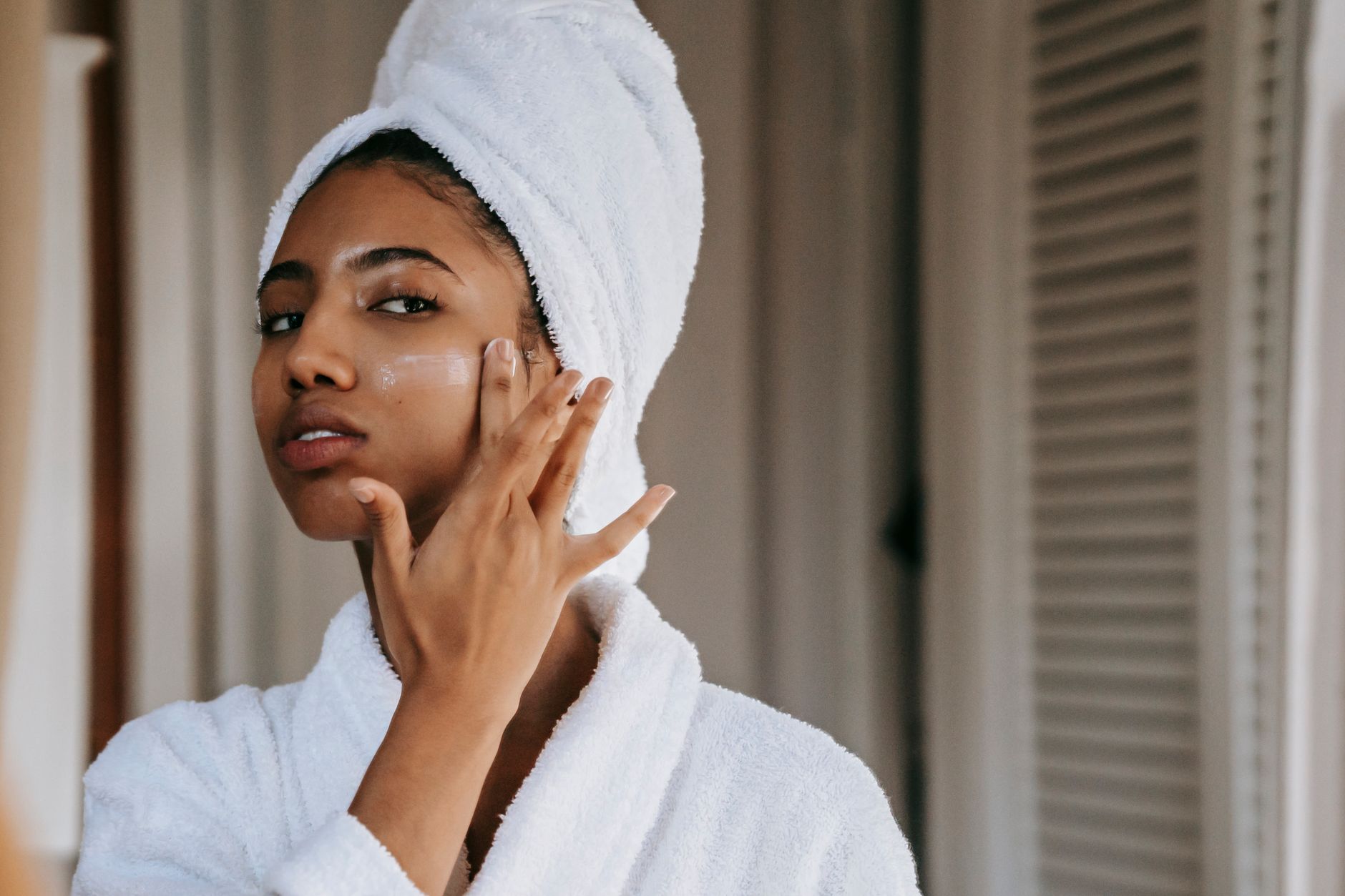 Femme qui applique une crème apaisante sur sa joue