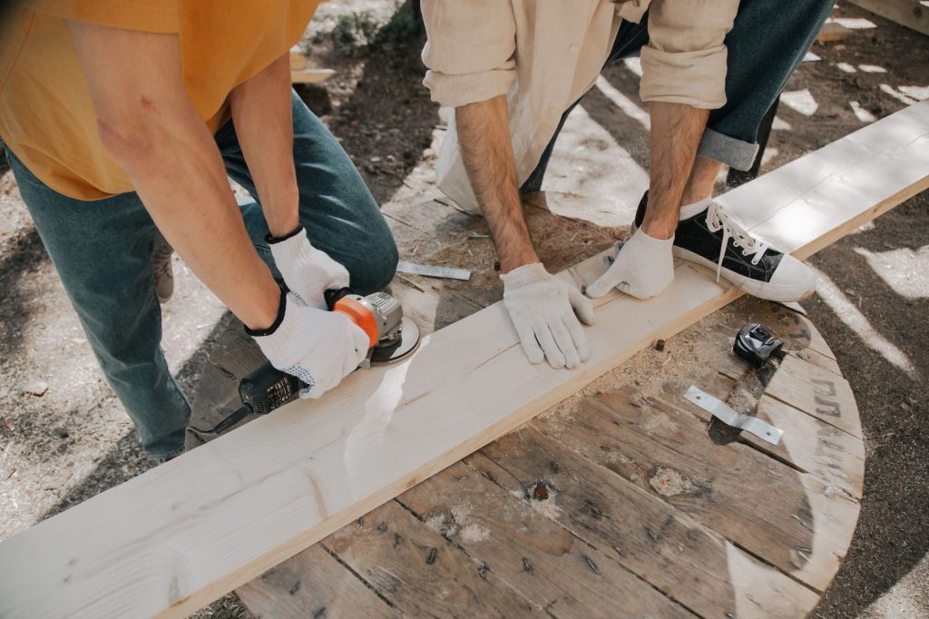 Deux artisans utilisant des outils electriques sur une planche de bois