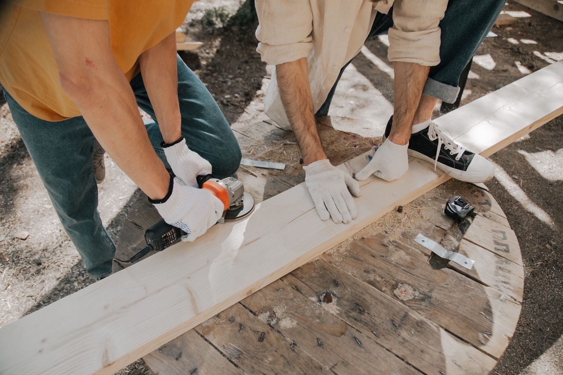Deux artisans utilisant des outils electriques sur une planche de bois
