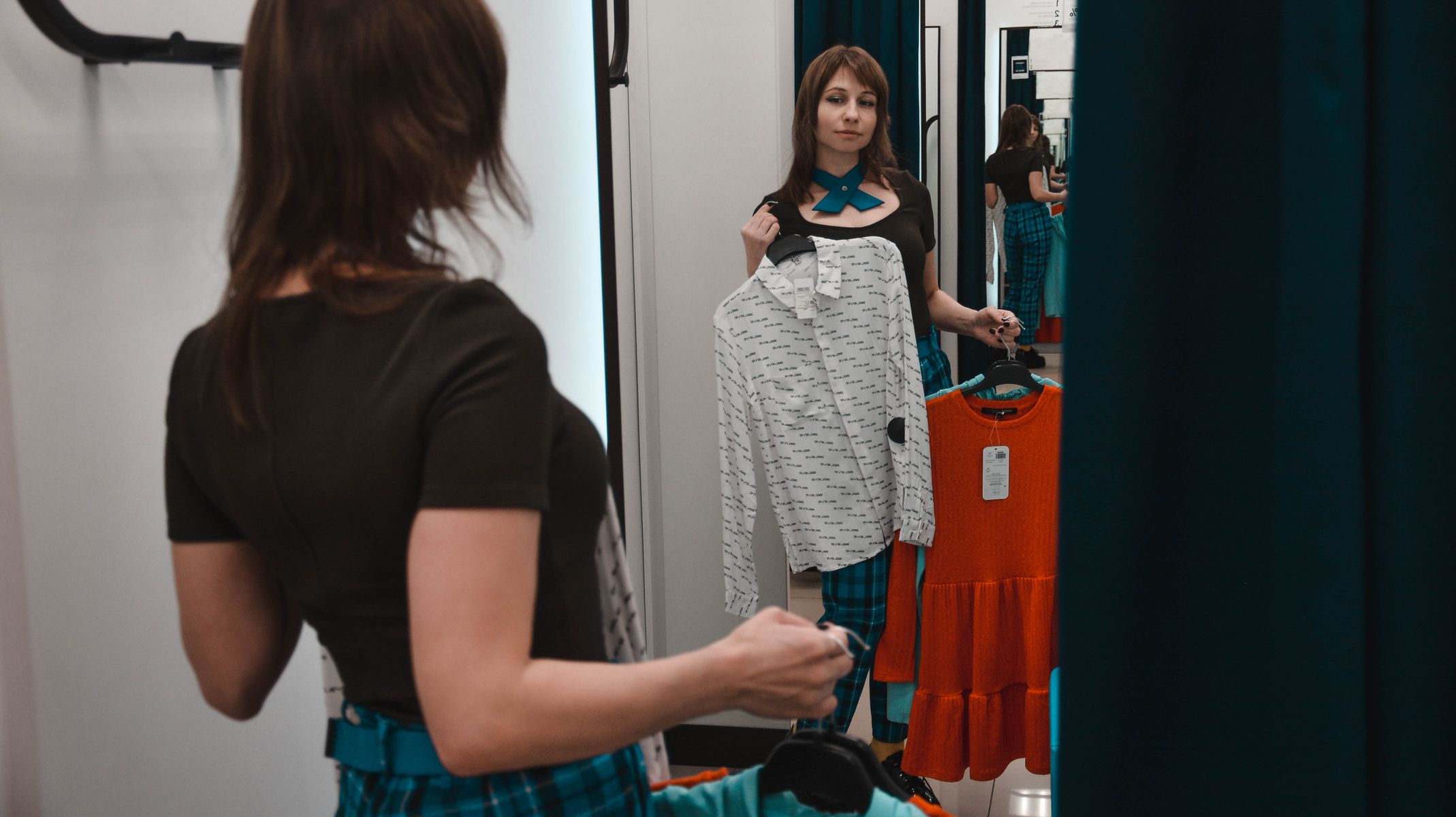 Femme de dos en cabine d essayage devant un miroir
