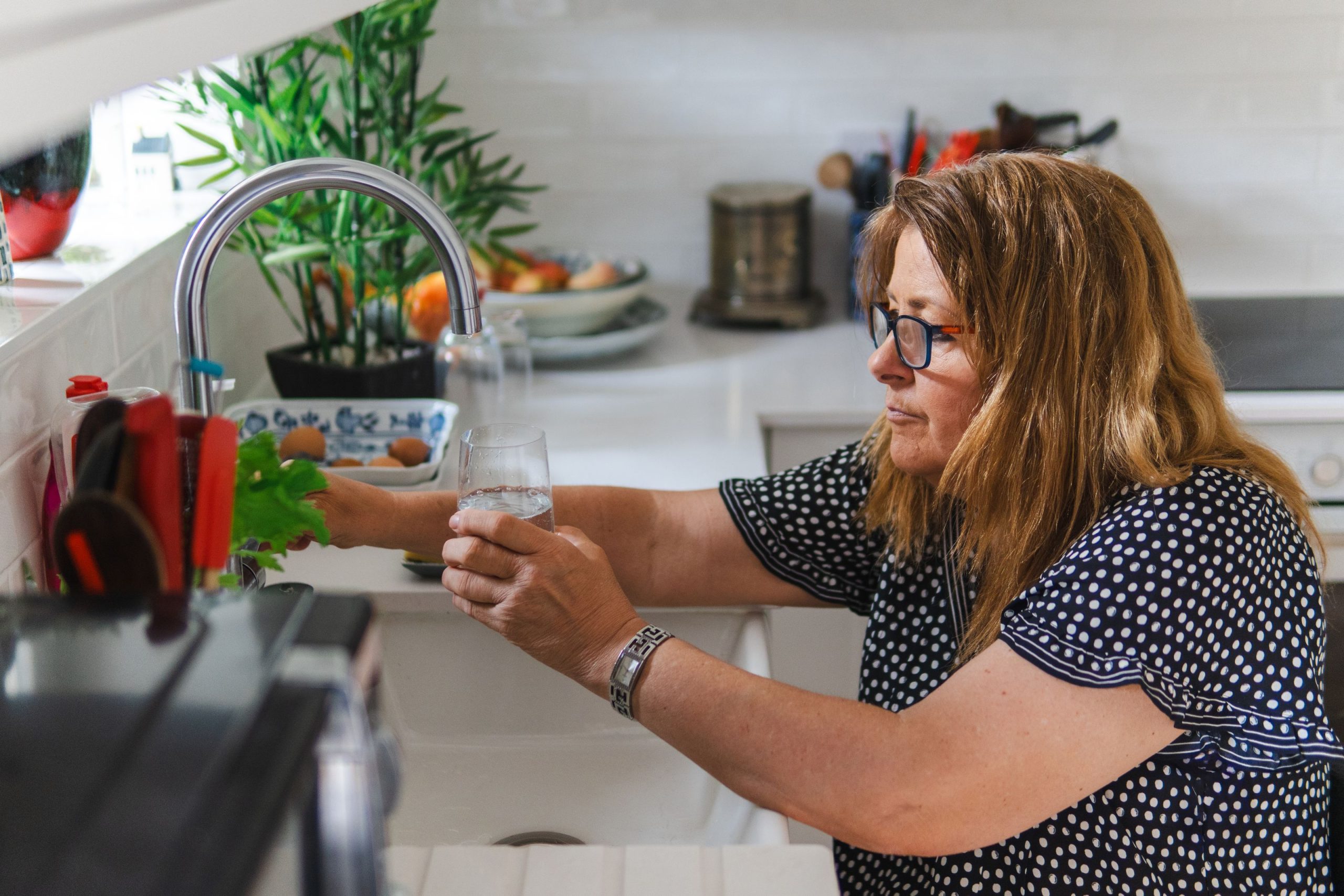 Femme qui remplit un verre d’eau