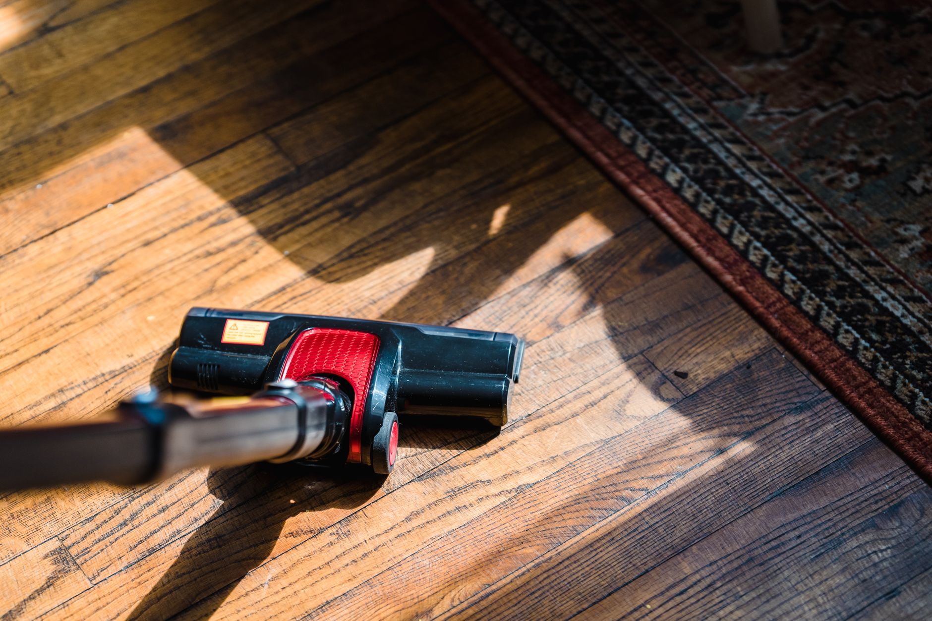 Aspirateur sur un parquet près d’un tapis